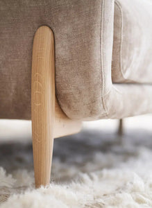 The Walcot velvet sofa with oak leg and fluffy carpet